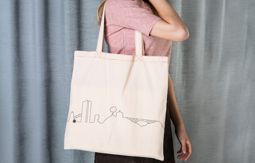 Tote bag beige avec marquage de la ligne graphique en noir de la skyline de carry le rouet